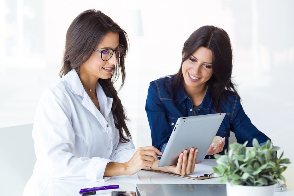 doctor-and-her-patient-choosing-mammary-prosthesis-in-the-office-min